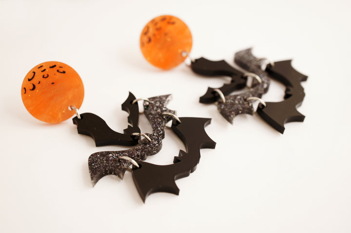 Halloween moon and bats earrings angle — spooky celestial acrylic jewelry — LaliBlue Midnight Cinema