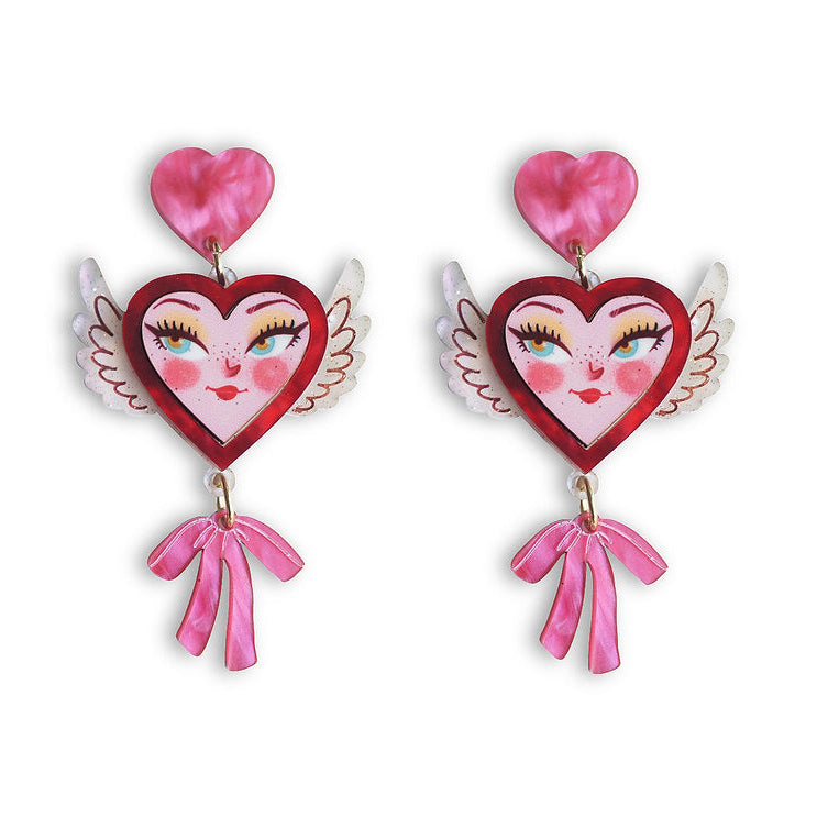 Heart-shaped earrings with wings and pink bows on a white background