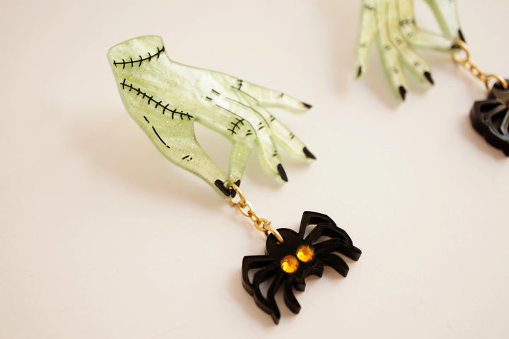 Zombie hands and spider earrings angle — acrylic horror statement jewelry — LaliBlue Midnight Cinema