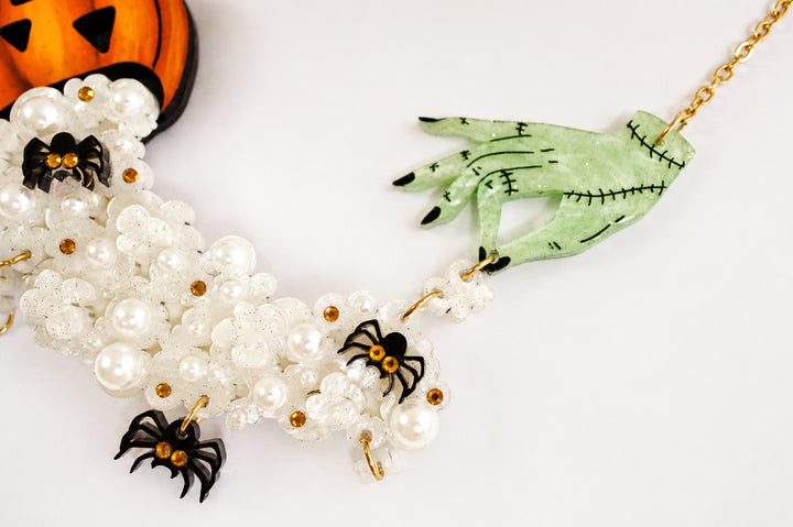 Zombie hand popcorn necklace close-up — articulated acrylic horror jewelry — LaliBlue Midnight Cinema