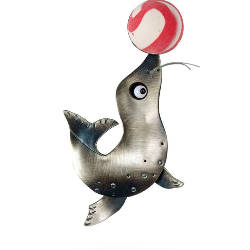 Chickenscratch Balancing Act Brooch — handmade nickel silver seal balancing a super ball on its nose, with swinging flippers and glass bead eye