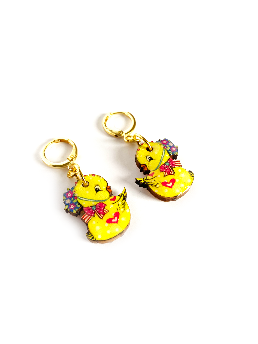 'Charlie the Chic drop earrings - with huggie hoops!' Cute Easter chic drop earrings featuring ducky the magical little baby chic. Beautifully illustrated in light in pastel and bright yellow. Incredibly comfy to wear, and beautifully made. Brighten up your easter with these special pieces of jewellery. Earrings basics * Measurement 6cm x 6xm * Bunny theme * Miss matched colours * Resin on woods creating a glass affect * Gold plated comfy huggie hoops * Perfect for day wear