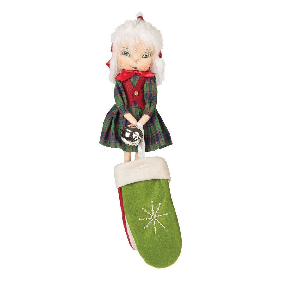 A handcrafted Ava Gathered Traditions mitten hanger with a doll-like figure in a green and red outfit, holding a green mitten with a snowflake design.