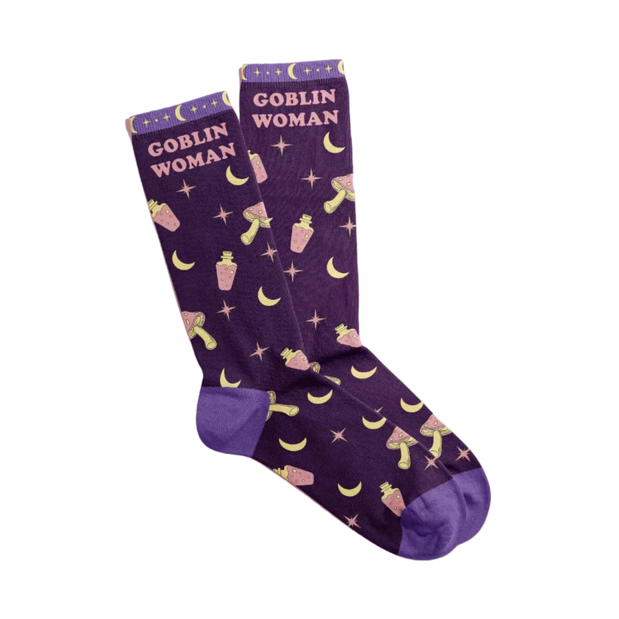Purple socks with 'Goblin Woman' text and moon designs on a pink background