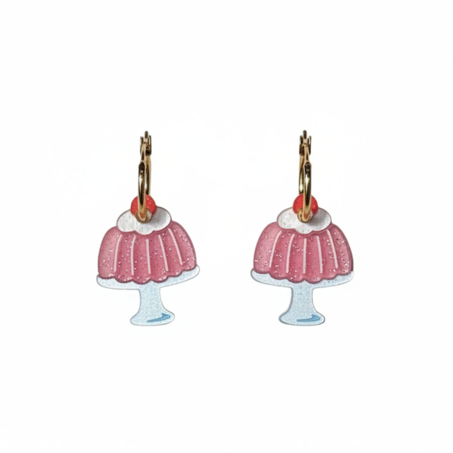 A pair of dangling jello mold earrings shaped like pink frosted cupcakes with gold-tone hooks and small red gem accents, shown on a plain white background.