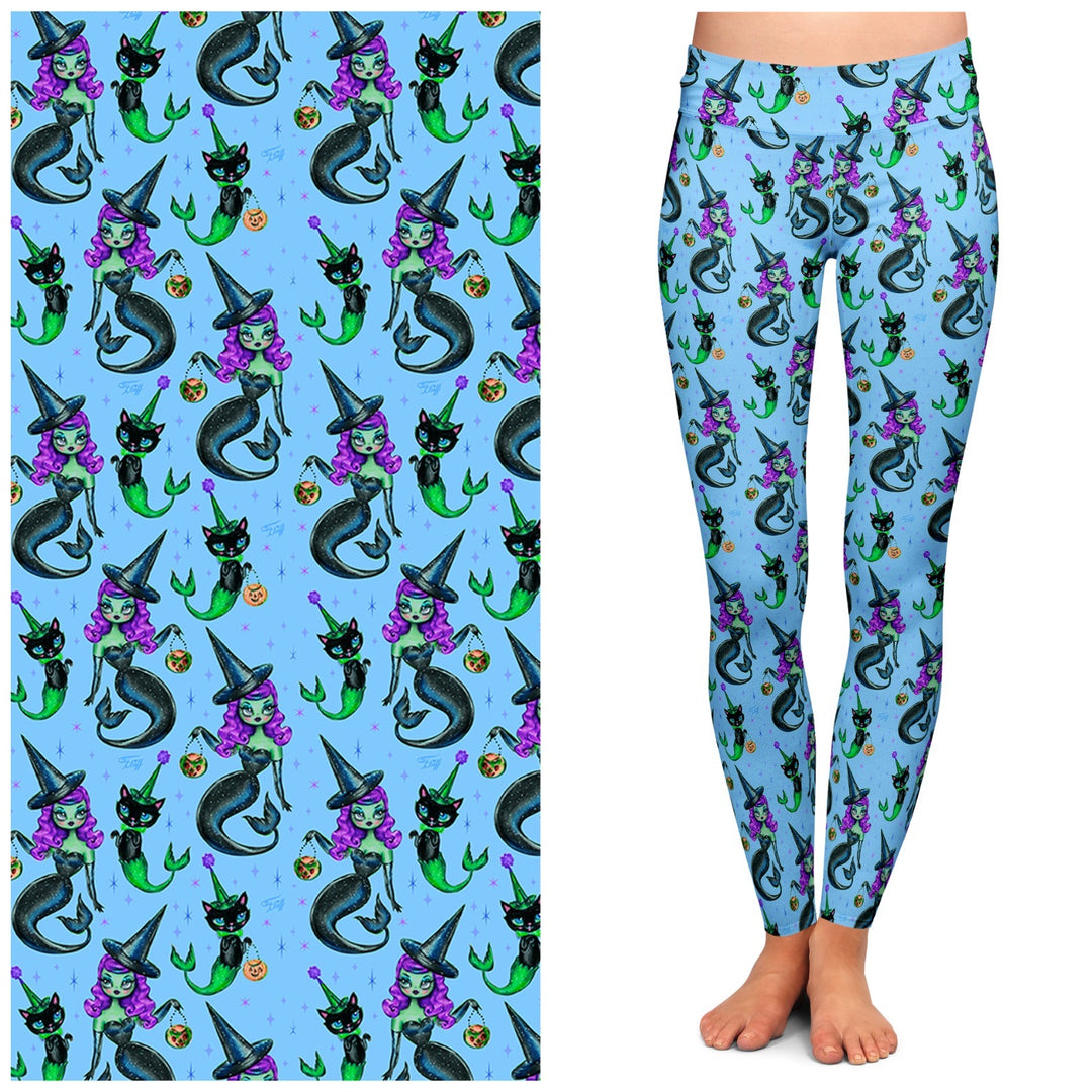 A pair of blue leggings featuring a pattern with mermaids, witches, and cats.