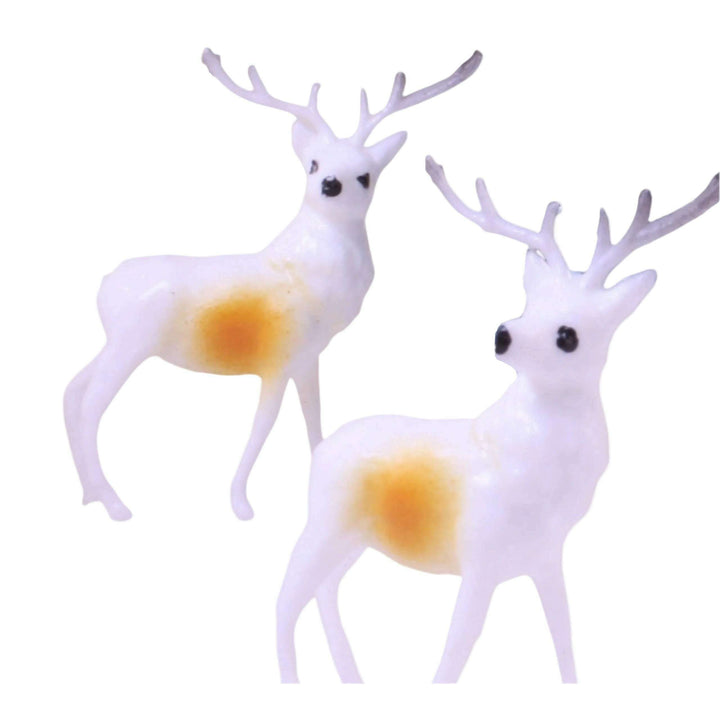 Two white deer figurines with yellow bellies on a white background