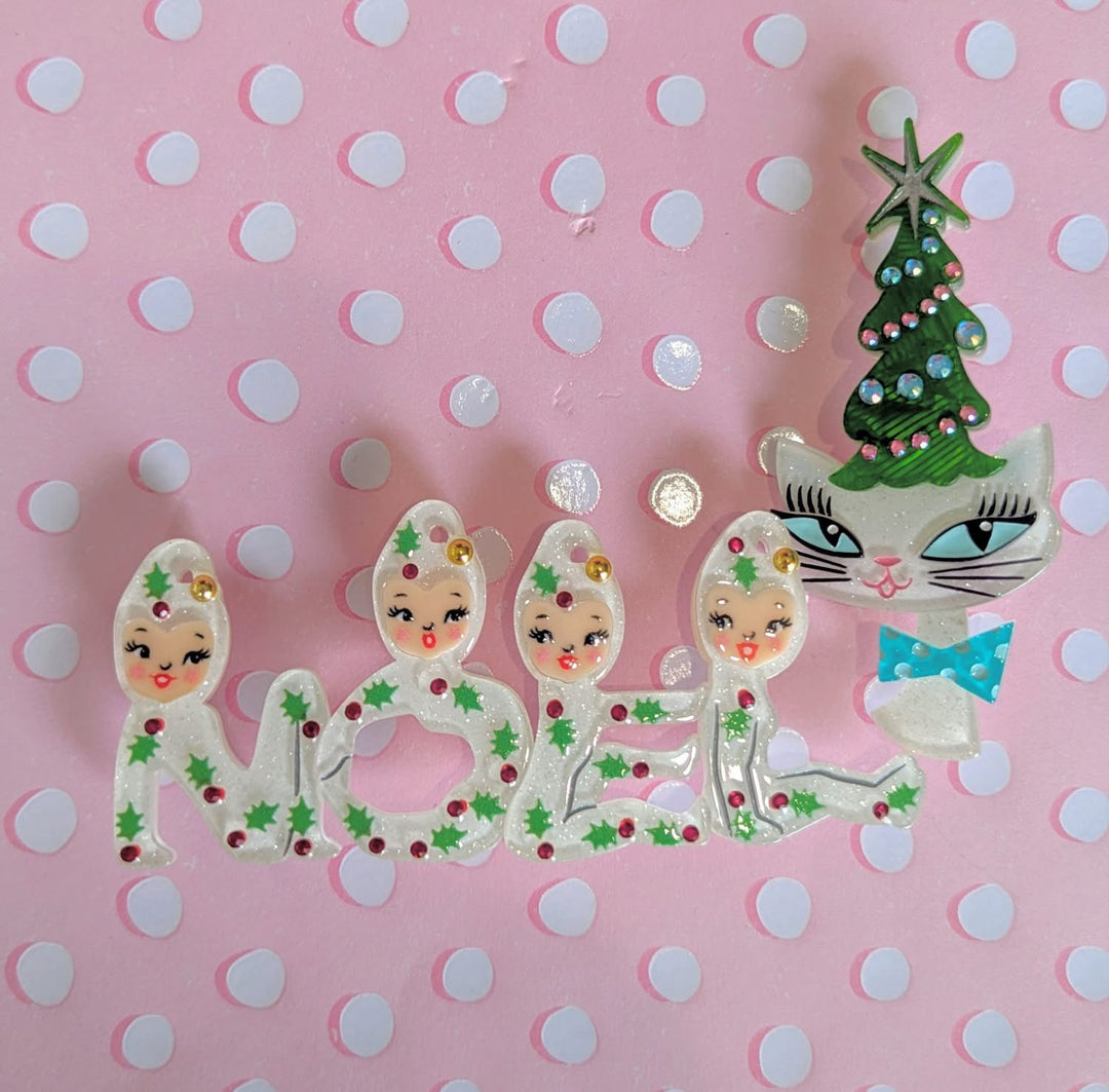 Decorative Christmas-themed letters spelling 'NOEL' on a pink polka dot background.