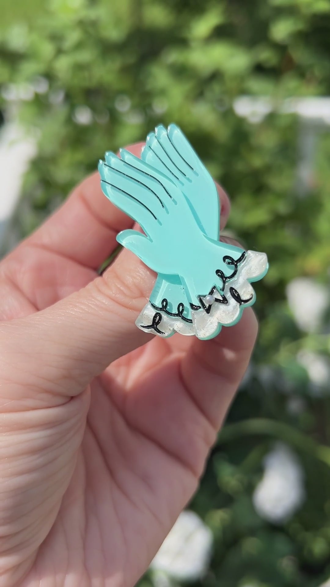 Video focusing on the details of the High Couture blue gloves brooch by Asia Ellington and Lipstick and Chrome.