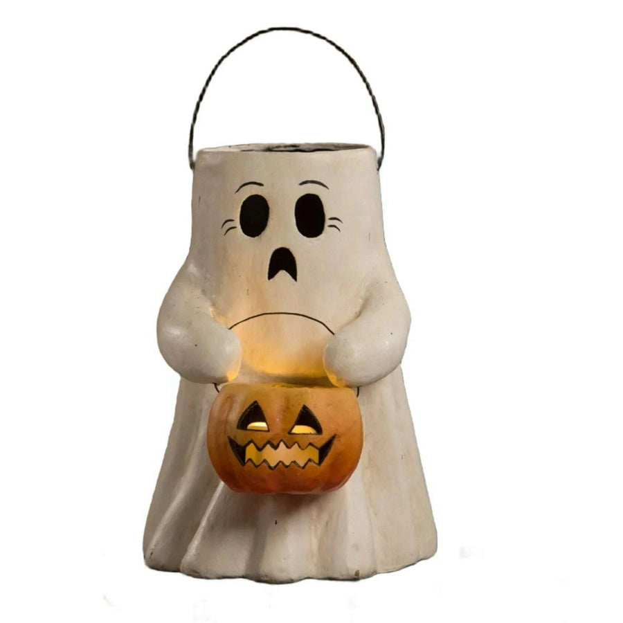 Ghost-shaped Halloween lantern holding a jack-o'-lantern on a wooden surface.