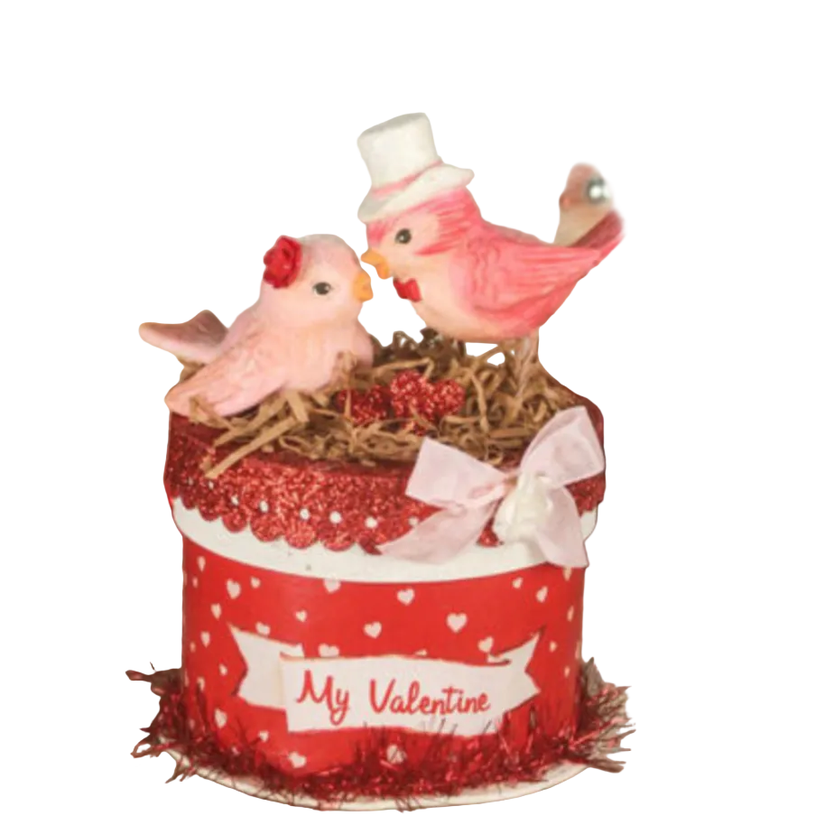 Decorative scene with birds on a red box labeled 'My Valentine' against a neutral background.